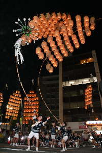 二人の男性が肩で竿燈を上げている画像。