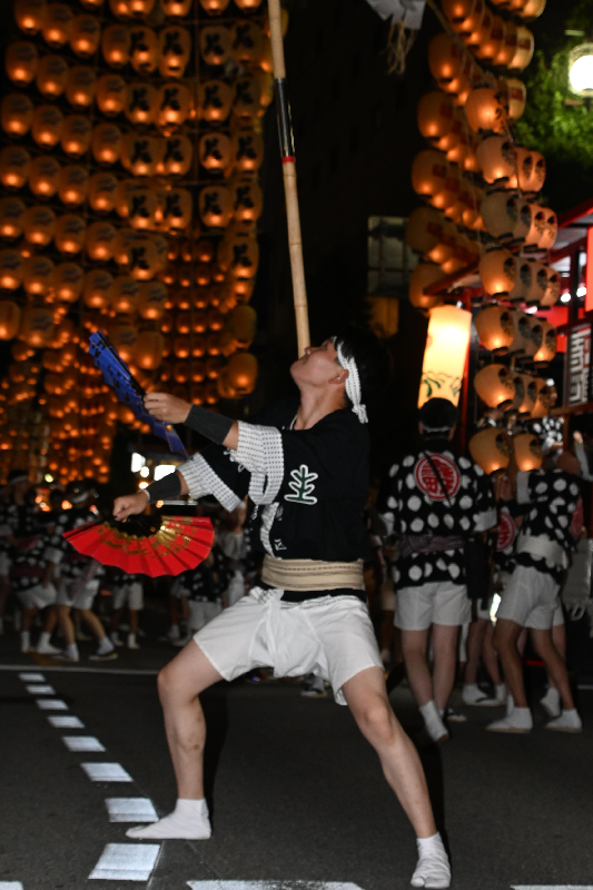 竿燈を上げ、両手に扇をもった男性の画像