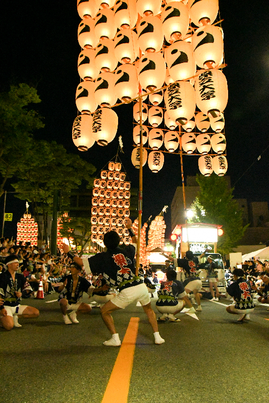 男性が竿燈を腰で支えている画像